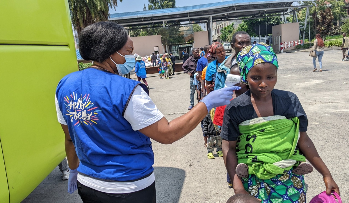 The returnees having their temperature checked after crossing into Rwanda on Thursday. Photo by Germain Nsanzimana.