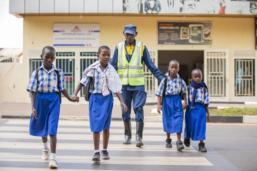 Augustin Munyaneza, 69-year-old, assists students to cross in Remera, ensuring that school children cross safely. Photos by Kellya Keza