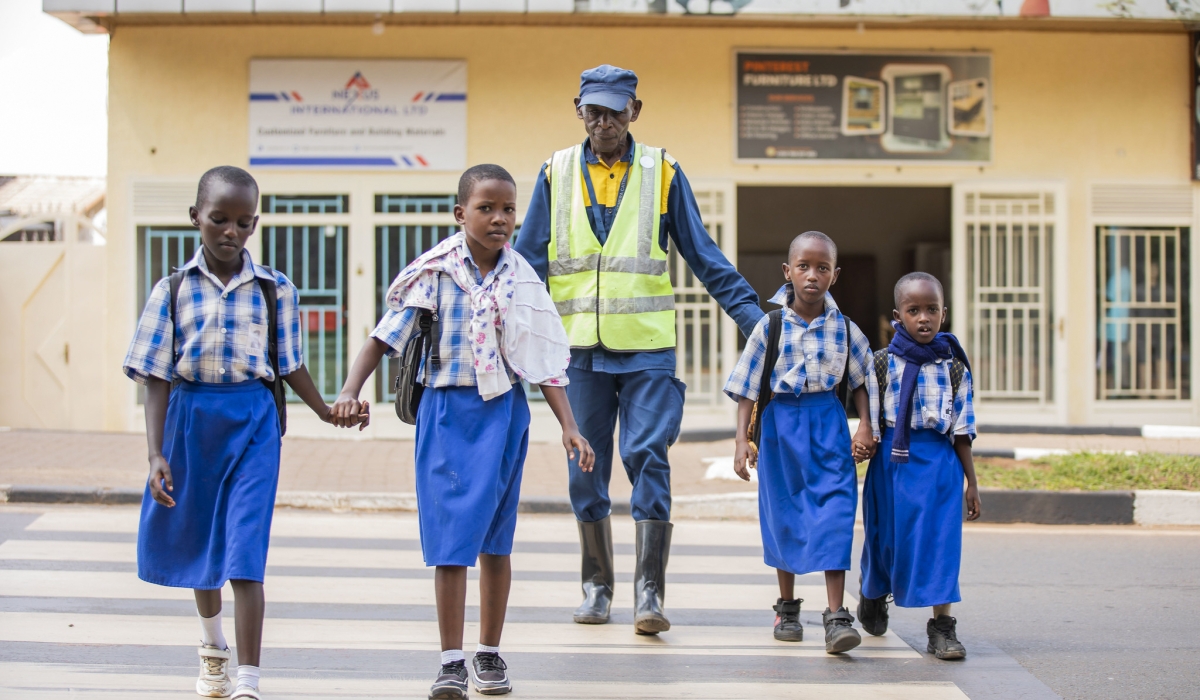 Augustin Munyaneza, 69-year-old, assists students to cross in Remera, ensuring that school children cross safely. Photos by Kellya Keza