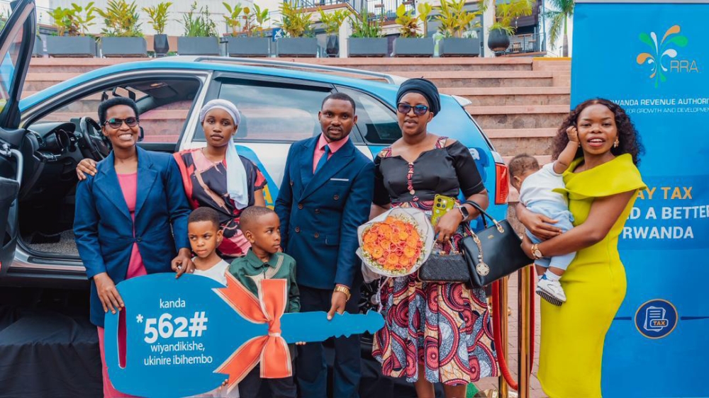 Hélène Murekatete from Bugesera District, surrounded by her husband, children, and close friends, receives the key to a Kia Sorento the grand prize she won through the TengaPromo lottery. Courtesy