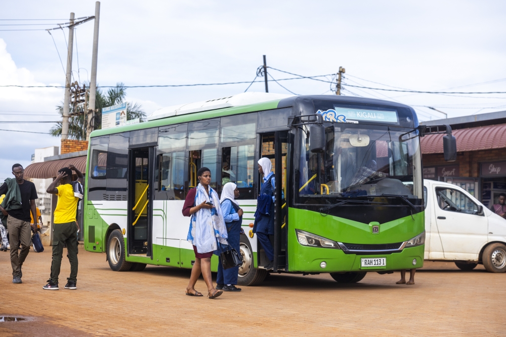 High school students board a bus in Masaka, Kigali. Private bus operators have expressed mixed reactions as the city rolls out a new service-led public transport model designed to ensure buses operate on fixed and predictable timetables for improved reliability. Photo by Olivier Mugwiza