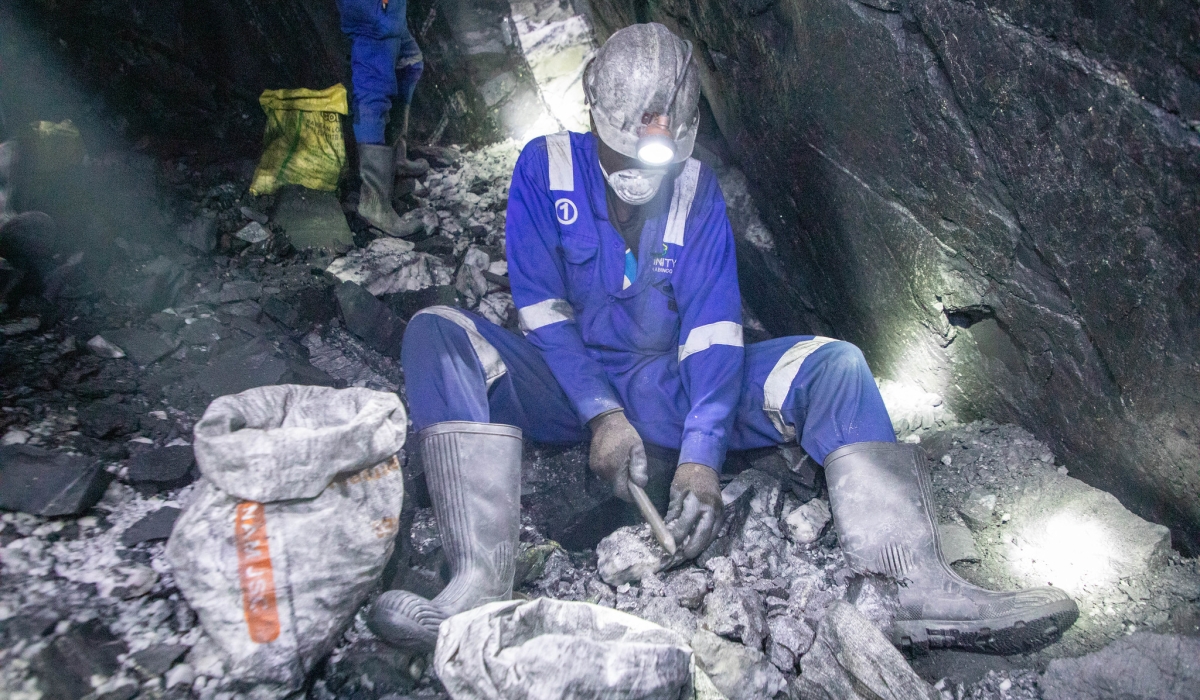A miner in protective gear works deep underground, manually breaking and sorting ore inside a narrow tunnel at the Nyakabingo Mining site on December 4. Photo by Craish Bahizi.