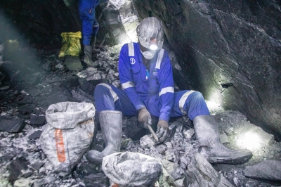 A miner in protective gear works deep underground, manually breaking and sorting ore inside a narrow tunnel at the Nyakabingo Mining site on December 4. Photo by Craish Bahizi.