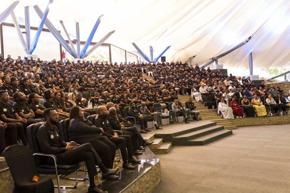 Mourners listen to a genocide survivor during a commemoration event.