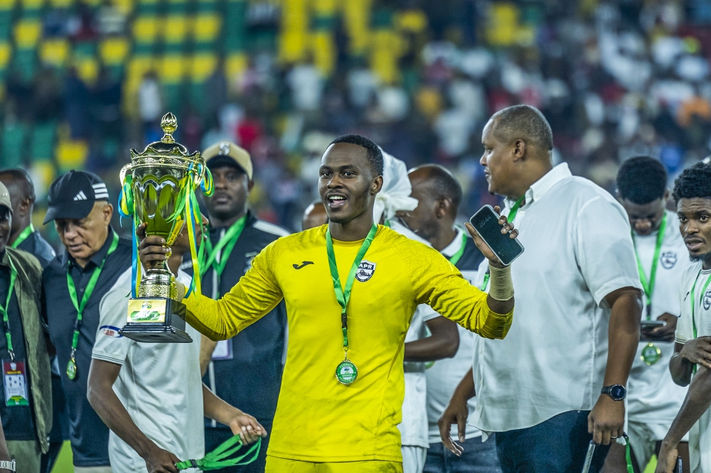 APR FC goalkeeper Adolphe Hakizimana holds the trophy during the celebration at Amahoro Stadium.