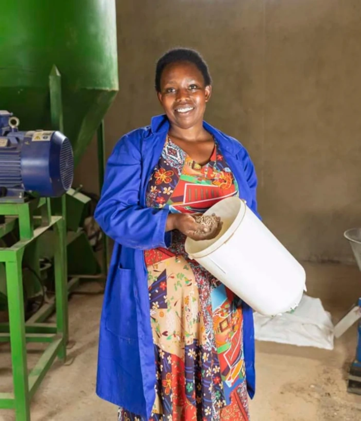 Clemence Murekatete with the feed-processing machine she purchased after winning a grant through the Mastercard Foundation-supported SAVE programme.