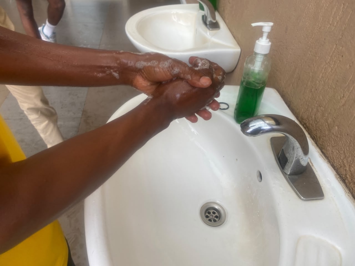 A man cleans his hands before accessing the Nyarugenge Market building
