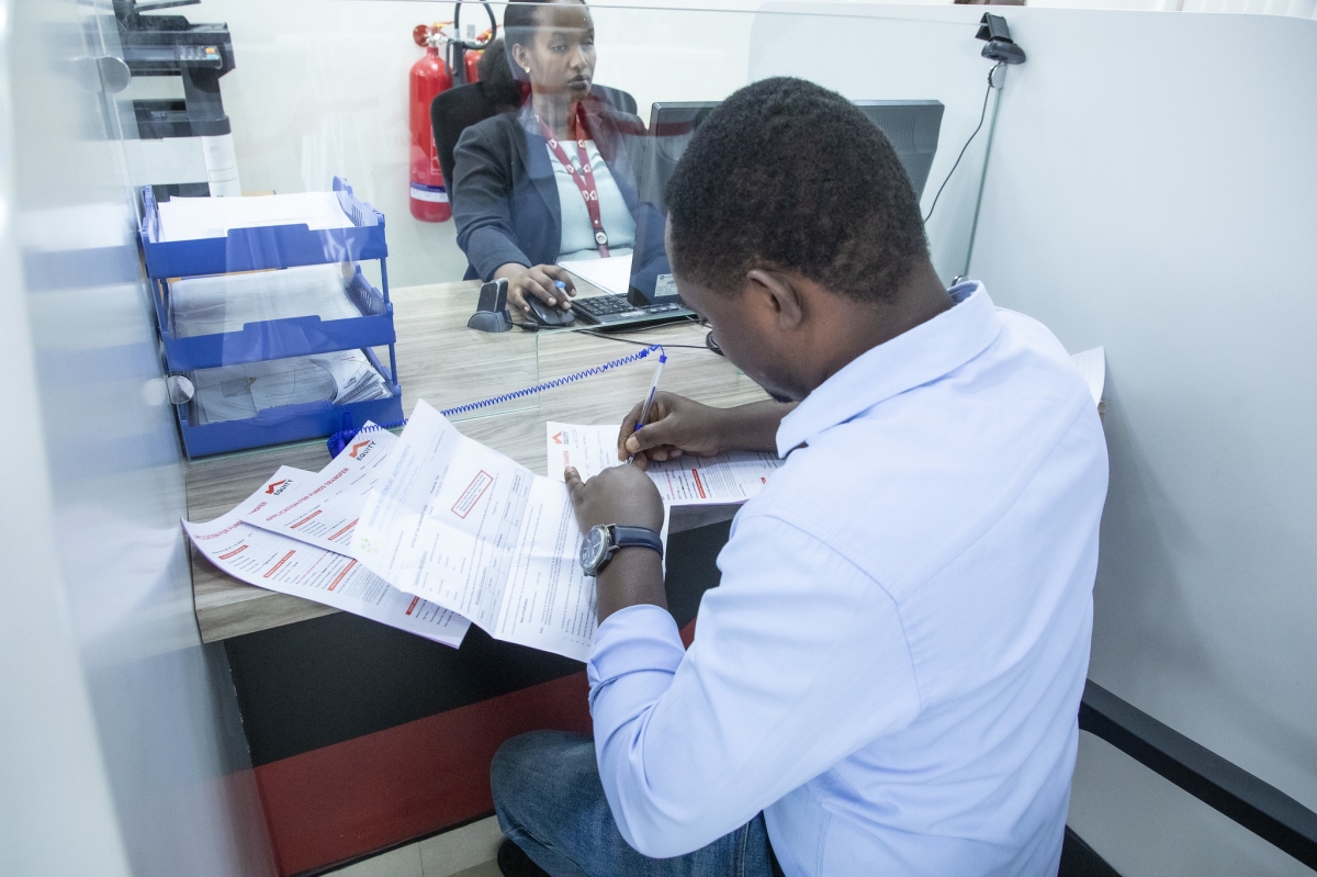 A client complete bank documents at the newly opened branch.
