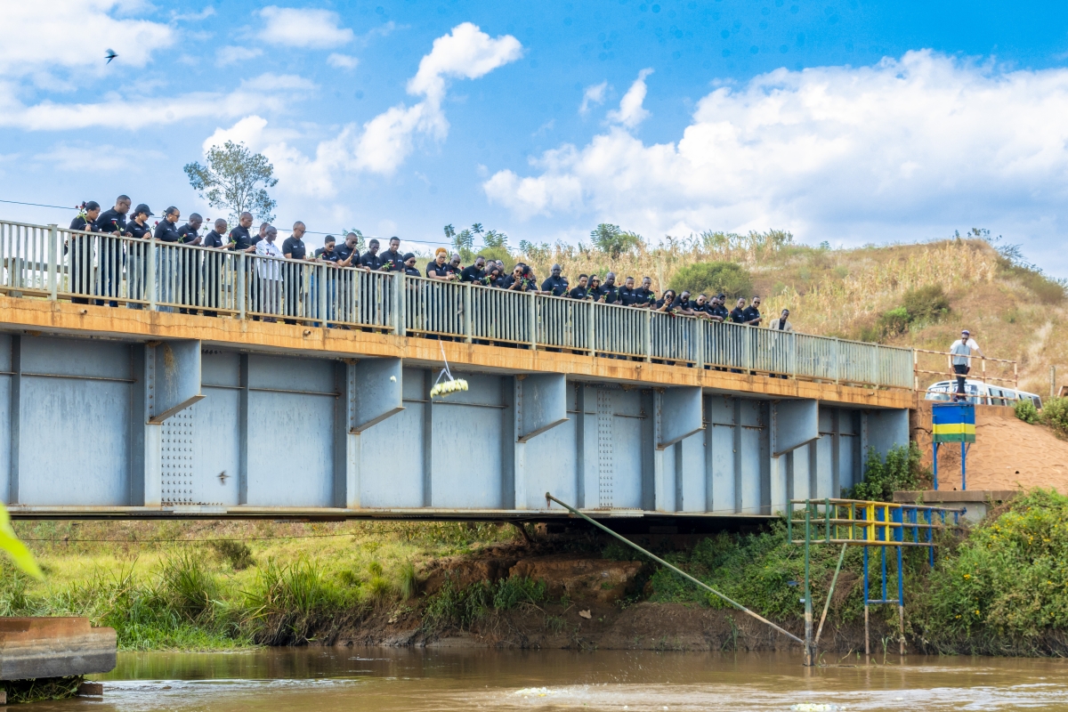 Members of Ubudasa Club cast flowers into the Akagera River in tribute to victims whose bodies were thrown into its waters during the genocide.
