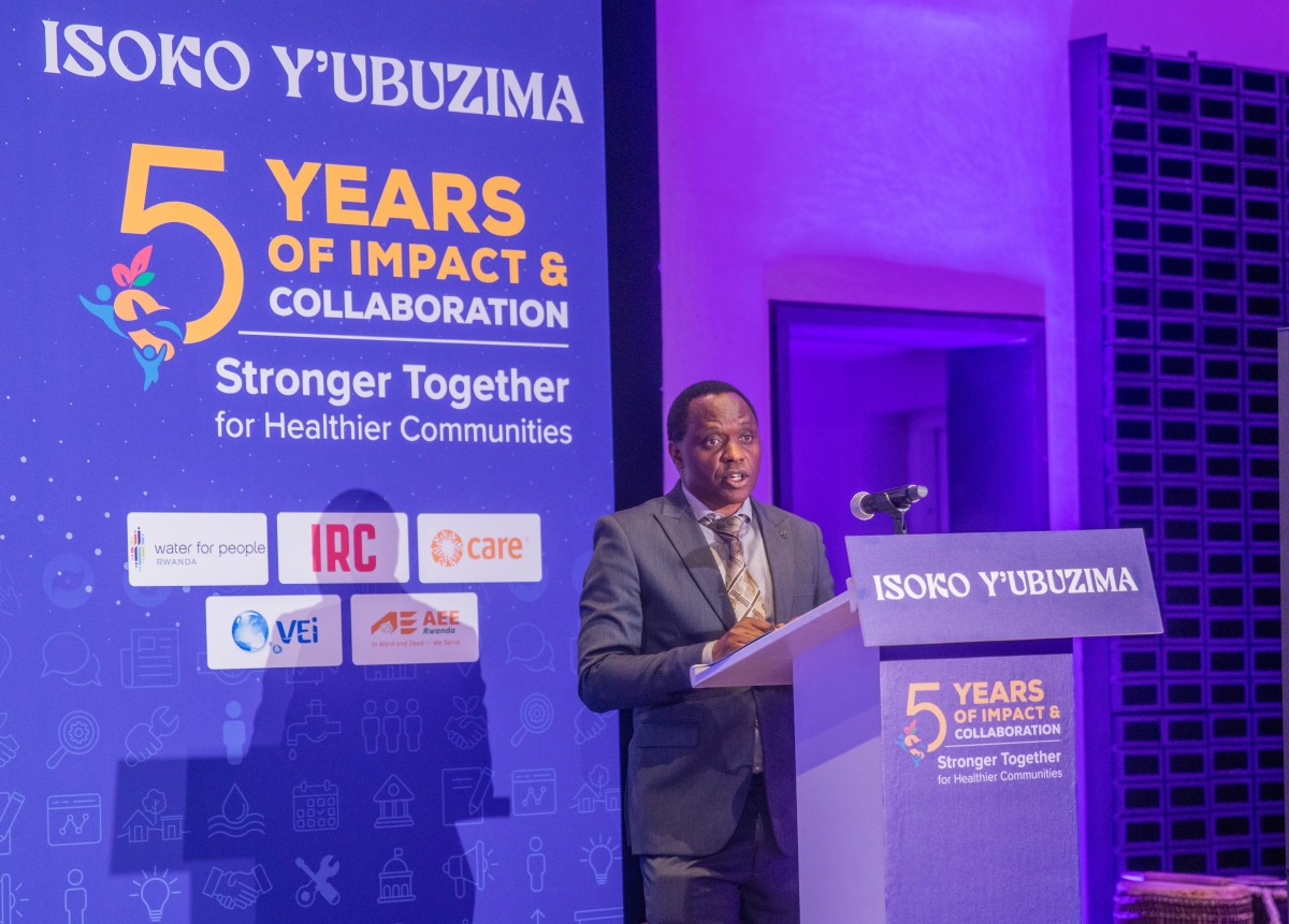 Eugene Dusingizumuremyi addresses participants, saying the project has improved access to safe water and strengthened long-term WASH systems. Photo by Craish Bahizi.