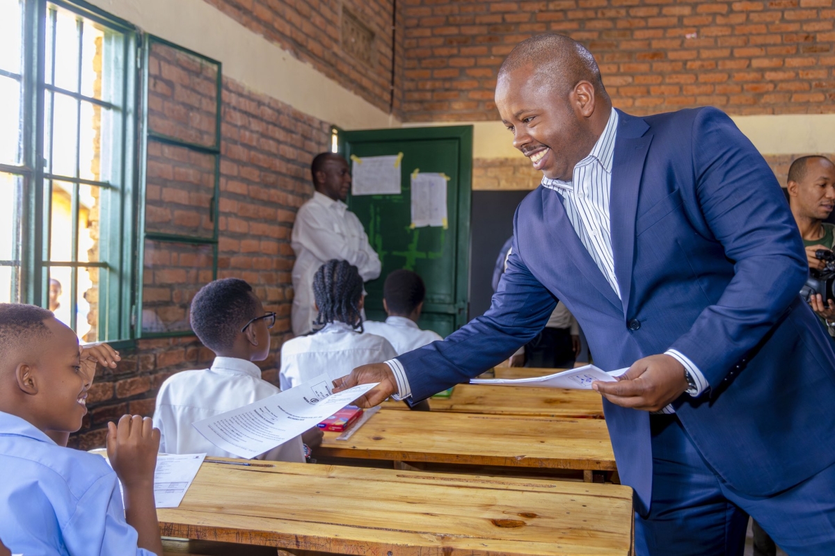 Mayor of the City of Kigali, Samuel Dusengiyumva, distributes copies of the national exams during the official launch in Kigali on Tuesday, July 7. Courtesy