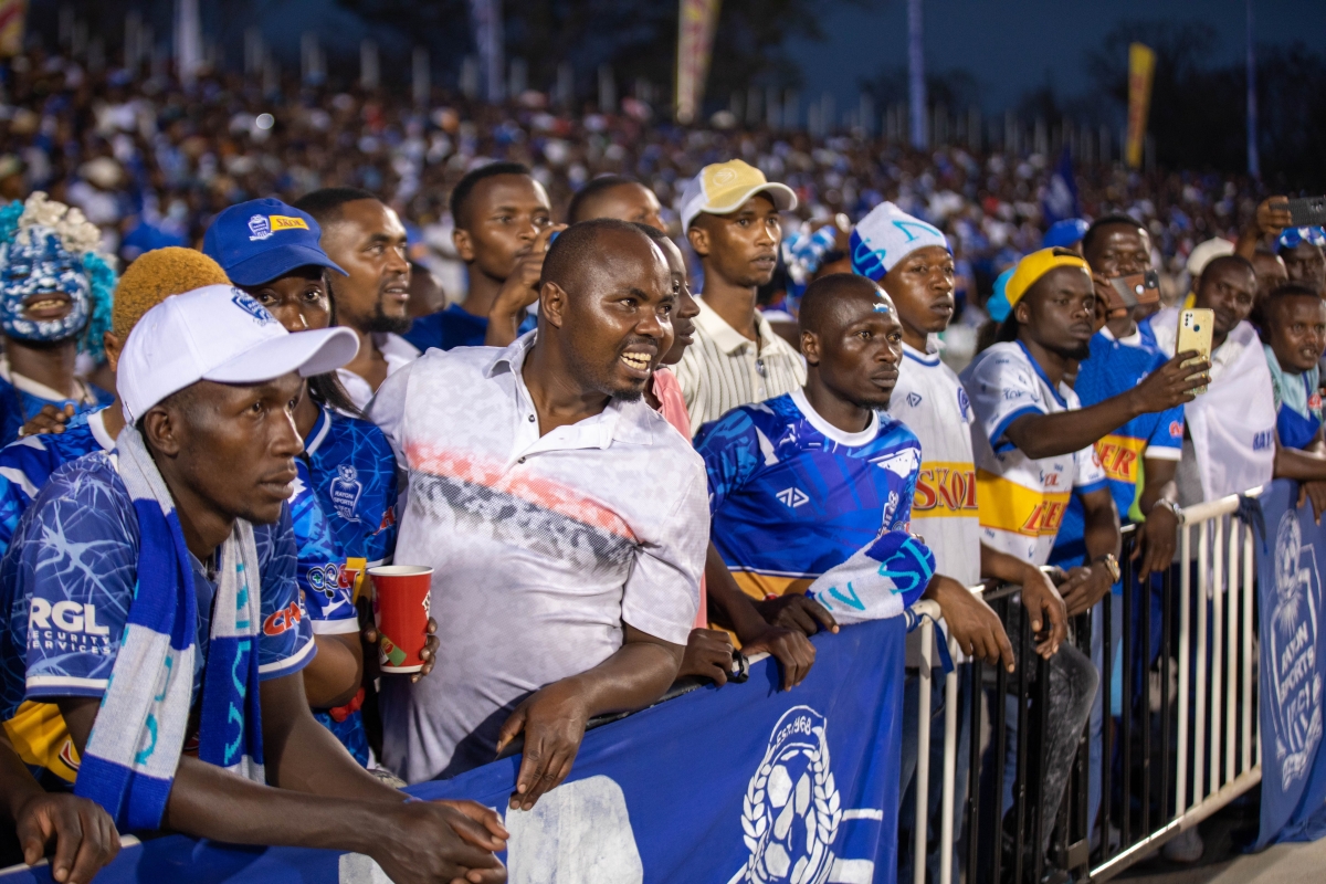 Football fans show unwavering support as they cheer their team on in front of a packed stadium.