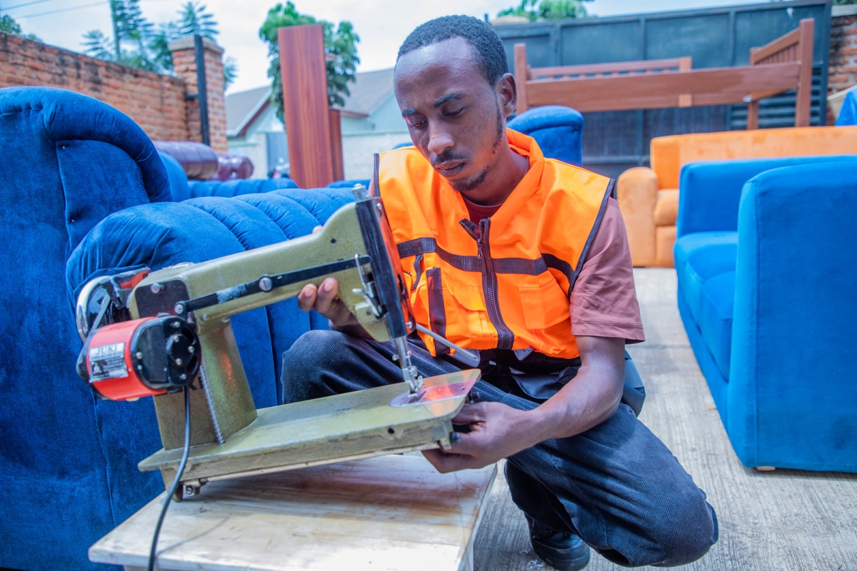 Muhawimana operates a sewing machine at Sibomana’s workshop in Busanza, where he applies skills gained after graduating from Iwawa.