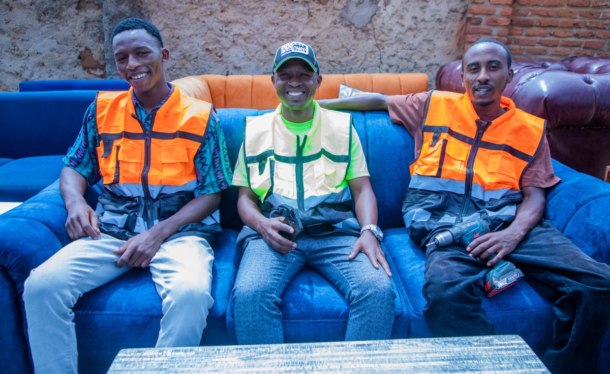 Sibomana (centre) alongside some of his employees, former Iwawa graduates Valentine Gasangwa and Abraham Muhawimana (right), at his carpentry workshop in Busanza.