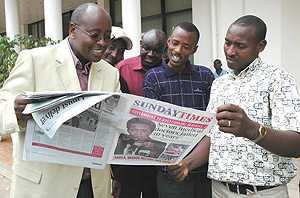 Musoni (left) and journalists peruse through a Sunday Times copy yesterday after the town hall meeting on media. (Photo/ J Mbanda)