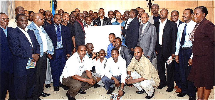 President Kagame (C) and Minister Nkusi (circled) pose for a photo with media managers and editors at Village Urugwiro on Tuesday after a two-day private meeting. The President received a birthday card from the media fraternity. (Photo/PPU)