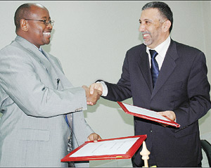 Musoni (L) and Abdulbaset exchange documents after signing the Rwandatel deal yesterday at Finance Ministry offices.