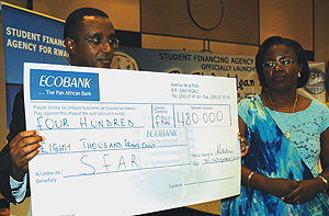 Dr Biruta showing off his cheque yesterday at Kigali Serena Hotel as Dr Mujawamariya looks on. (Photo/ G. Barya)