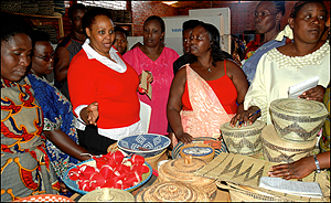 Nkubana (centre) stresses a point to a group of women who were admiring locally made baskets (agaseke) at Gahaya Links  yesterday. (Photo/ J. Mbanda)