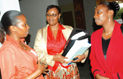 WHAT NEXT: Mukabalisa (centre) holding a copy of the report in company of MPs Dora Urujeni (left) and Jaquelline Muhongayire at Parliamentary Buildings, Kimihurura, on Tuesday. (Photo/J. Mbanda)