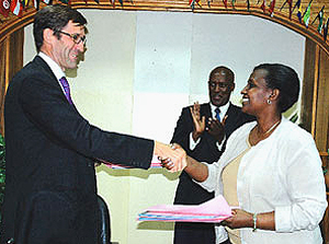 Ambassador Roux (left) shakes hands with Museminari after signing the agreements as Wellas Mukama, the in - charge of the Europe desk, applauds. This was at offices of the Foreign Affairs ministry. (Photo/ G. Barya)