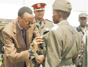 Kagame decorates 2nd Lt. Jacqueline Uwamahoro, who emerged the best officer cadet during the just concluded course at Rwanda Military Academy, Gako, yesterday. (Photo/G. Barya)