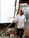 A man surveys the damage of a collapsed house in Cyangugu. (Photo / K. Llewellyn)