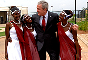 ABOVE: Bush poses for a photo with Rwandan traditional dancers at the US Embassy offices