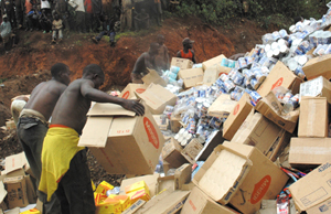Street boys look on as expired foodstuffs from BENALCO are destroyed at Nyanza in Kicukiro on Wednesday. (Photo/ J. Mbanda)
