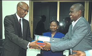 The outgoing board chairman of HIDA Barnabu00e9 Sebagabo (R) handing over all the documents to the new board Chairman David Himbara at Hida offices yesterday. (Photo/ G.Barya)