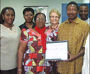 SNV Country Director Jean de Matha Ouedraogo (R) receives a certificate from Profemmesu2019 Ruboneka. (Photo/S. Nkurunziza)