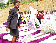 A young survivor examines the coffins containing remains of victims before they were buried at Kigali memorial site Gisozi on Monday. (Photo / J. Mbanda)