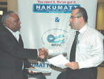 The Managing Director of Nakumatt,  Atuh Shah (L), shakes hands with City market boss Mohamed Bakrt after signing the deal in Kigali on Monday. (Photo/ G. Barya)