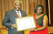 Dr. Clet Niyikiza ,Vice President Oncology Medicine Development and main sponsor of the Aimu00e9e U. Niyikiza Memorial Award giving a certificate to Gorreth Ingabire  the first Rwandan Medical Journal award Friday at Hotel Serena. (Photo/GBarya).
