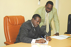 Health Minister Jean-Damascu00e8ne Ntawukuliryayo signs while Global Fund Country coordinator Daniel Ngamije looks on. (Photo/ Mbanda John).