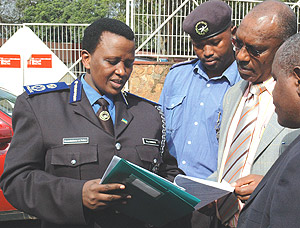 Commissioner General of Police Mary Gahonzire (L) and her Burundian counterpart Fabien Ndayishimiye (2nd right) read through road safety regulations on Tuesday while Traffic Police Commander Robert Niyonshuti (C) looks on. This was during the launch of th
