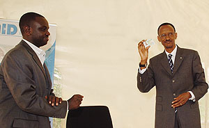 I HAVE GOT MINE, GO GET YOURS: President Paul Kagame (R) displays his National ID shortly after launching the National ID distribution process yesterday. (Photo/ G. Barya)
