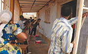 MEN AT WORK: Aegis Trust Fund and Kigali Memorial Site paint genocide survivoru2019s house in Kiturusu, Remera. (Photo G. Barya).