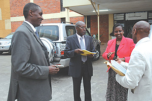 Jean de Dieu Mucyo (L), who chaired the inquiry into the role of the French in the Genocide, with other members of the commission, hands over the report to the Minister of Foreign Affairs, Rosemary Museminari, outside the Ministry of Justice buildings.(Ph