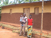 Harerimana and his wife with one of their two kids in front of their new house. (Photo/ B. Asiimwe)