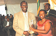 MTNu2019s Rugege (L) receives the companyu2019s trophy for Best Over all Exhibitor from Commerce Minister, Monique Nsanzabaganwa at the closing ceremony. (Photo/ J.Mbanda).