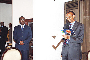 President Kagame reads a commemorative card presented to him by Prime Minister Bernard Makuza on behalf of members of cabinet at a celebration to mark the 5th annivesary of his swearing in as President. (PPU photo).