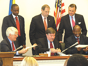 Finance minister James Musoni (R) signing the deal with the US government yesterday. Next to him is MCC deputy CEO, Rodney Bent (C) and and USAIDu2019s James Kunder. Looking on (standing from left) are Kimonyo, Arietti and Symington. (Photo/ MCC)