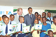 Smart kid: President Kagame watching admiringly as one of the beneficiaries of the One Laptop Per Child project shows off his skills. (File photo)