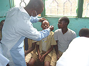 SAY AH: A dentist takes checks a young boyu2019s teeth during the launch or the Oral Health Awareness Week yesterday. (Courtesy Photo).