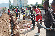 Workers laying optic fibre cable in Kigali City ( File photo)
