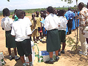 Green Hills Academy pupils giving scholarstic materials to their Mbyo Primary School counterparts. (Courtesy Photo).