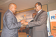 Prime Minister Bernard Makuza (right) presents Hassan Lumumba of Dash-s-technologies with the best ICT Start up Company award. (Photo/G.Barya).