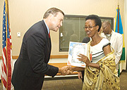 US Ambassador to Rwanda Stuart Symington congratulates Louise Uwamariya of CORWAR after signing  a grant agreement at the US Embassy. (Photo G.Barya).