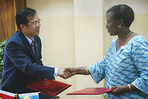 The Minister of Foreign Affairs RoseMary Museminari, shakes hands with China Ambassador Sun Shuzhong after signing Grant of 10 million RMB Yen. (Photo/G. Barya).